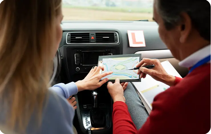 Deux personnes consultant une carte routière à l'intérieur d'un véhicule pour planifier un itinéraire