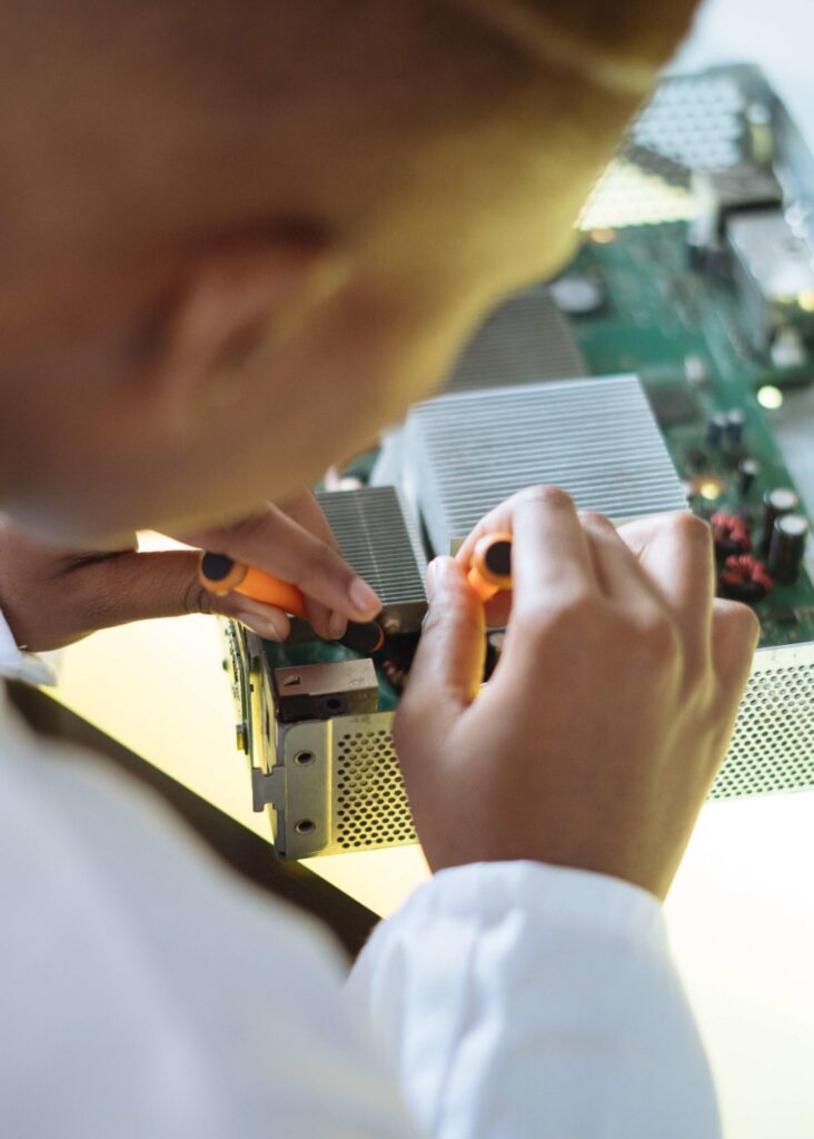 Technicien intervenant sur un équipement électronique à l’aide d’outils de maintenance.