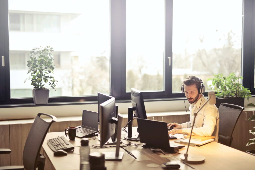 Technicien support travaillant sur plusieurs écrans dans un bureau équipé de matériel informatique