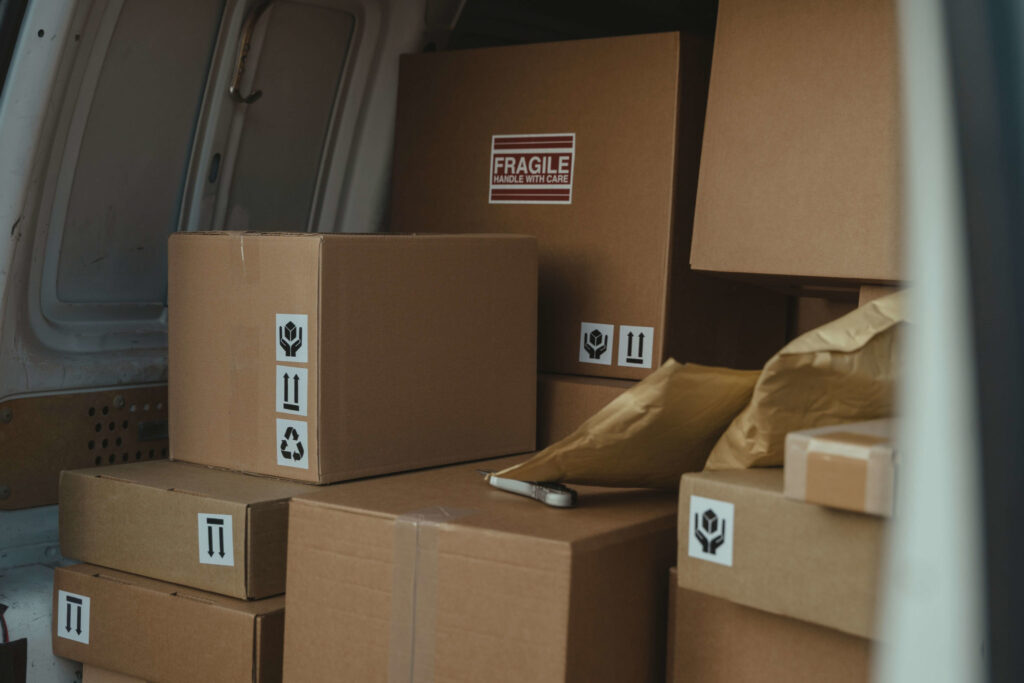 Colis de différentes tailles chargés dans un véhicule de livraison pour l’expédition et le suivi des marchandises.
