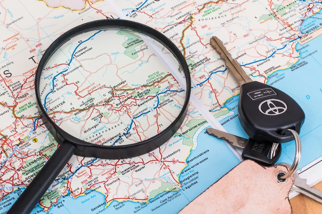 Dans l'image, une loupe est combinée avec une clé de voiture équipée d'un traceur d'entreprise pour retrouver facilement le véhicule.