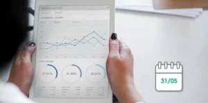 Une personne utilise l'outil-MERIDE sur une tablette pour analyser un rapport financier affichant des graphiques et des pourcentages
