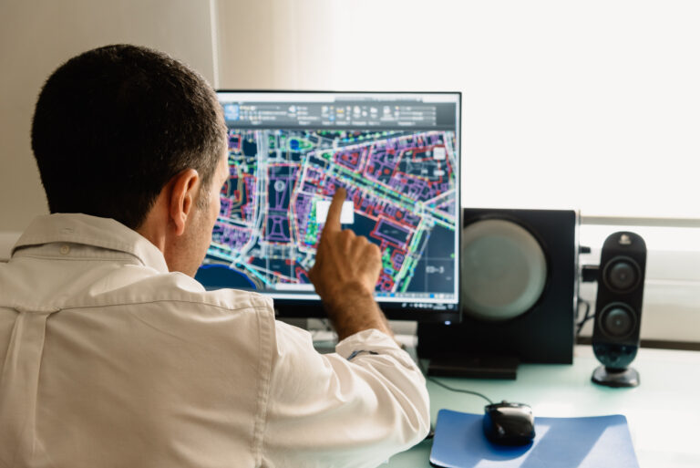 Professionnel analysant une carte numérique sur un écran pour planifier des interventions terrain